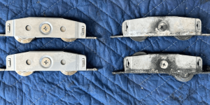 New and worn impact sliding glass door roller assemblies before replacement